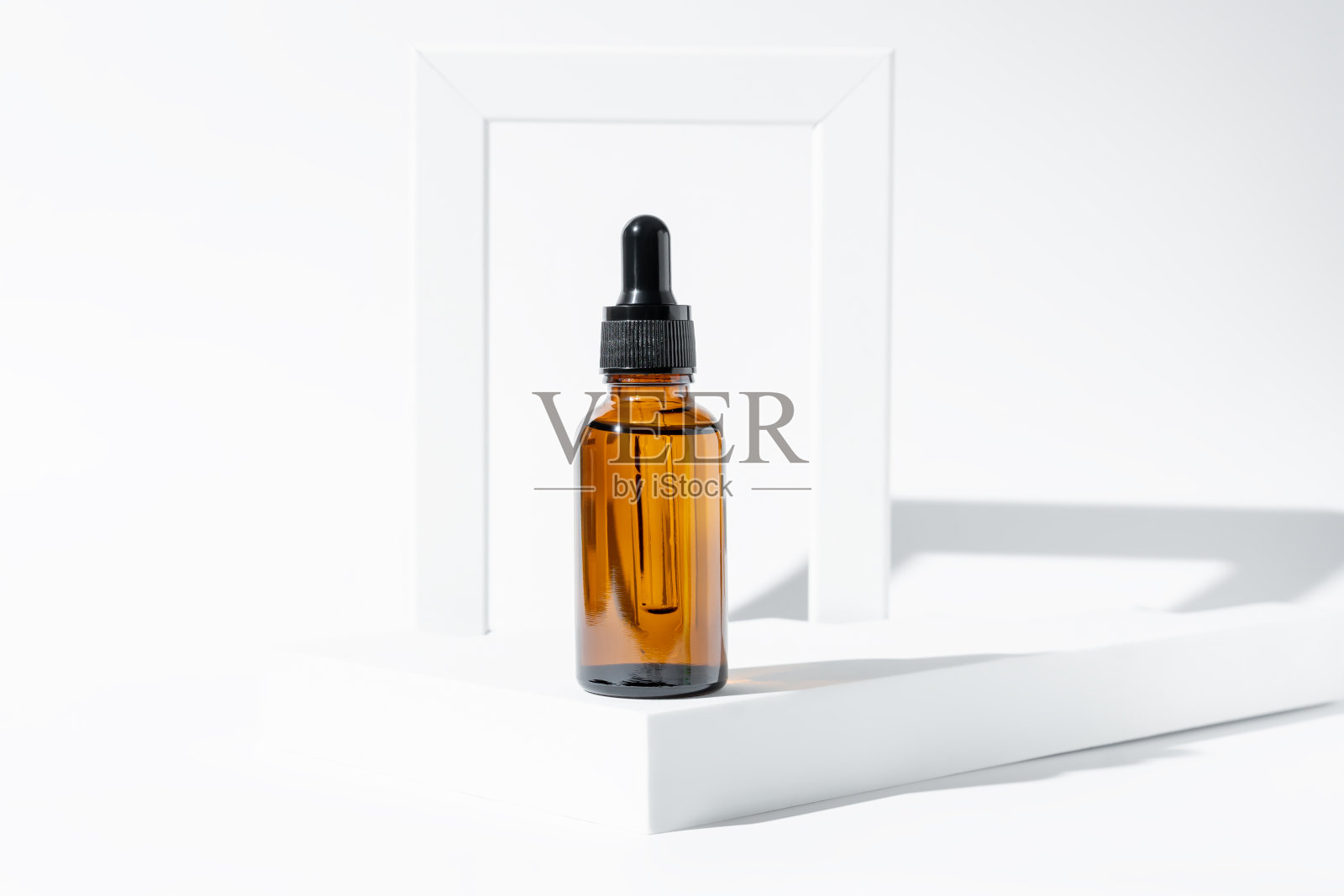 白色讲台上带吸管的琥珀色化妆瓶，产品包装，带肽的抗老化血清，化妆品模型，水疗概念。照片摄影图片