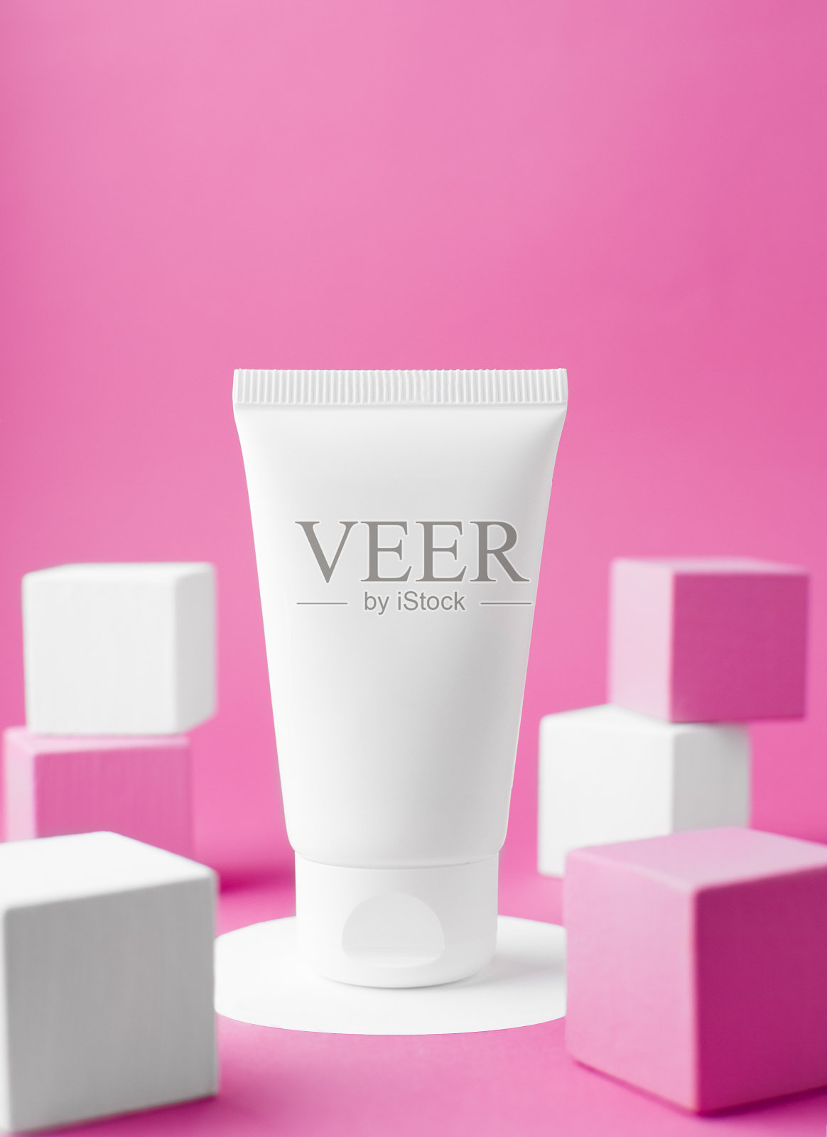 在一个圆形的架子上有一个白色的乳白色管的模型，旁边是粉色和白色的讲台。创意化妆的照片。照片摄影图片