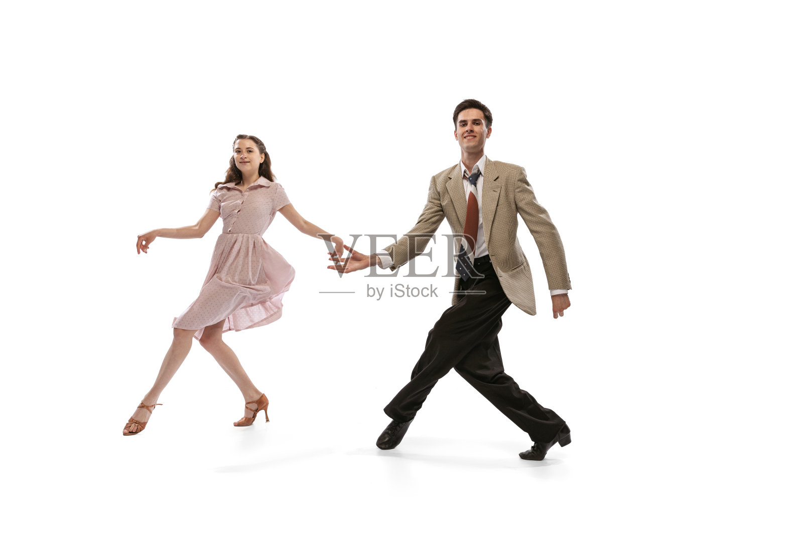 年轻的男人和女人在复古复古风格的服装跳舞社交舞蹈孤立在白色背景。永恒的传统，20世纪60年代美国时尚风格和艺术照片摄影图片