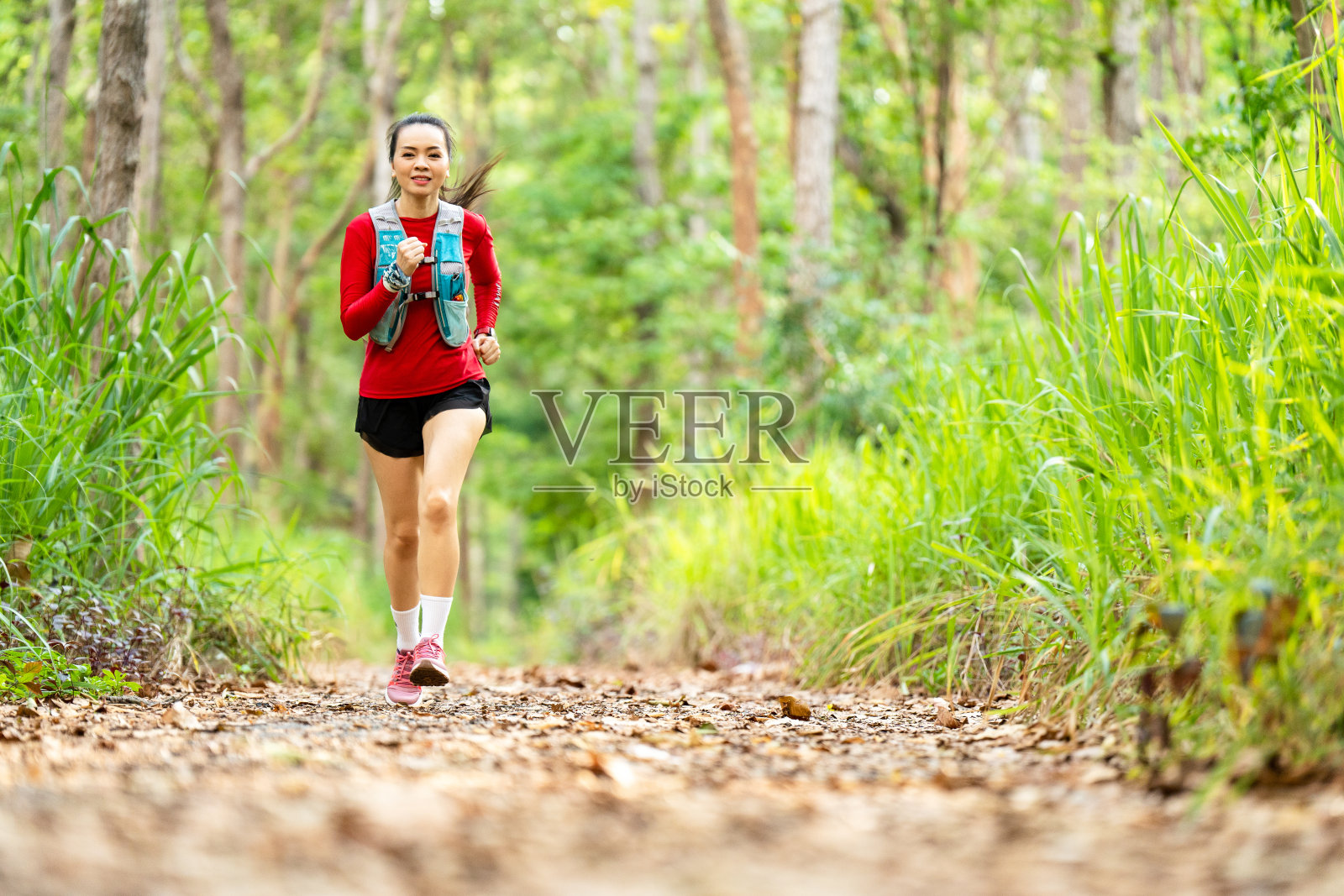 亚洲中年妇女晨跑在森林小径户外运动照片摄影图片