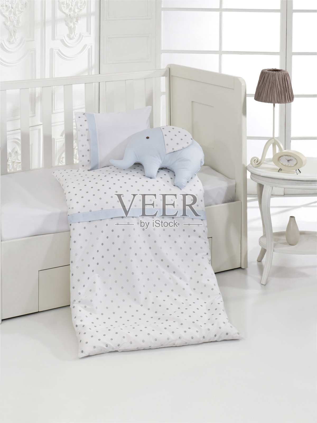 枕头和玩具在白色的木制毯子在明亮的苗圃照片摄影图片