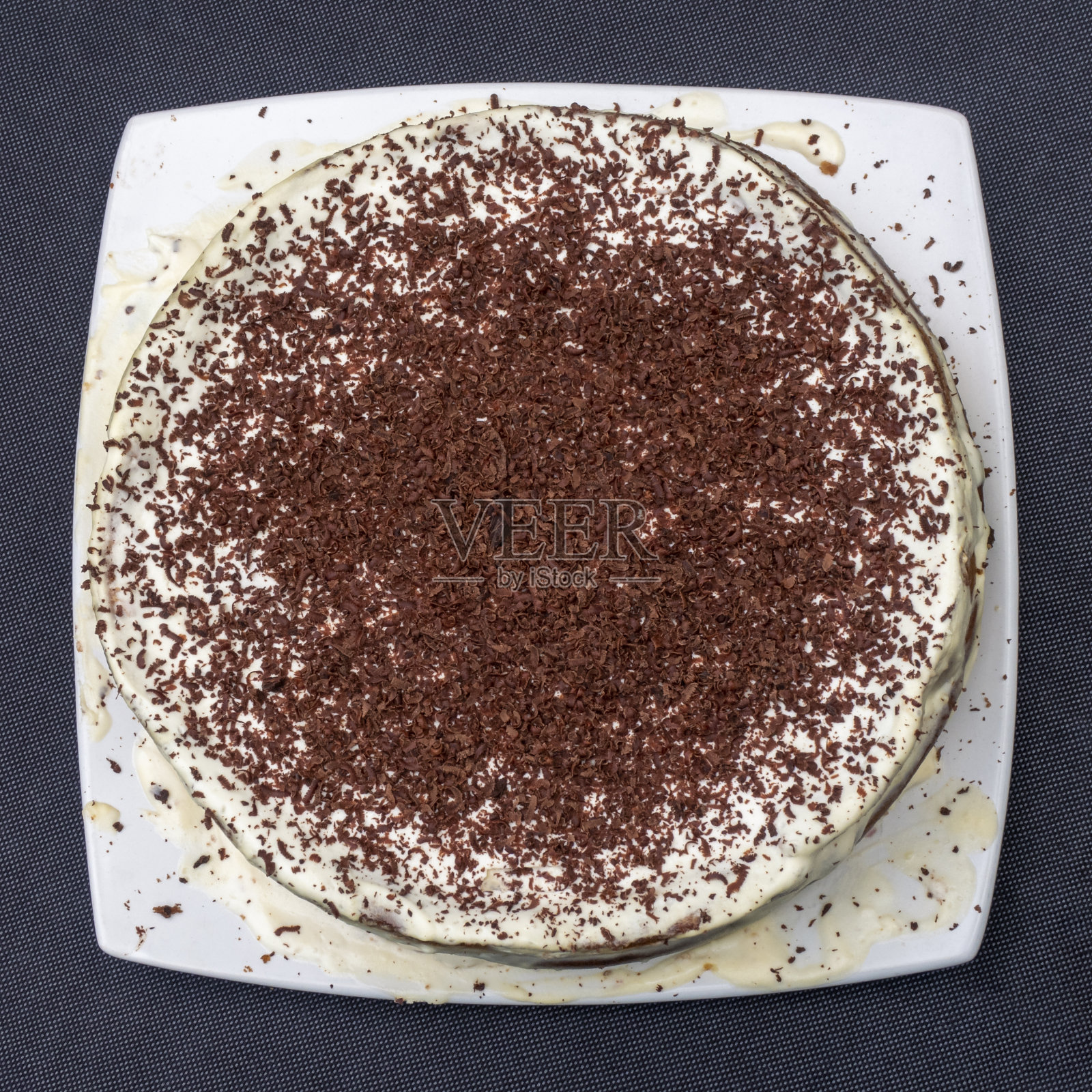 手工制作的蛋糕，白色的盘子上装饰着巧克力屑。平的观点。照片摄影图片