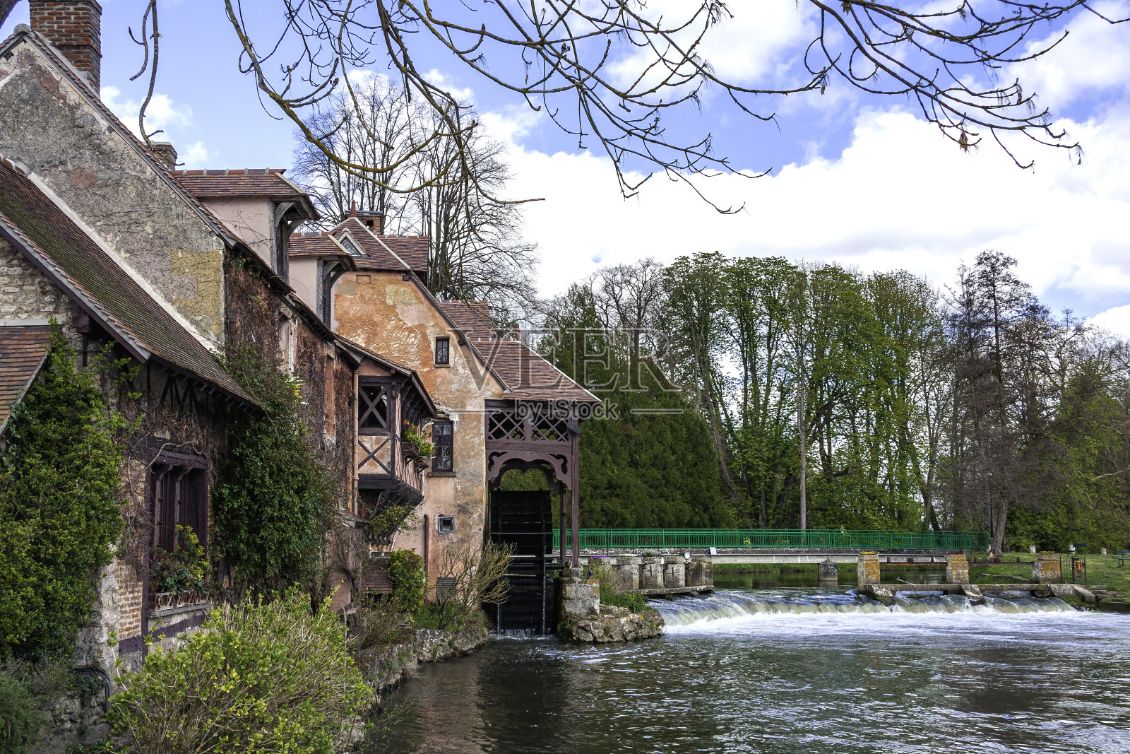 巴黎附近风景如画的法国小村庄，坐落在水坝上的一座桥旁，旁边有一个水车照片摄影图片