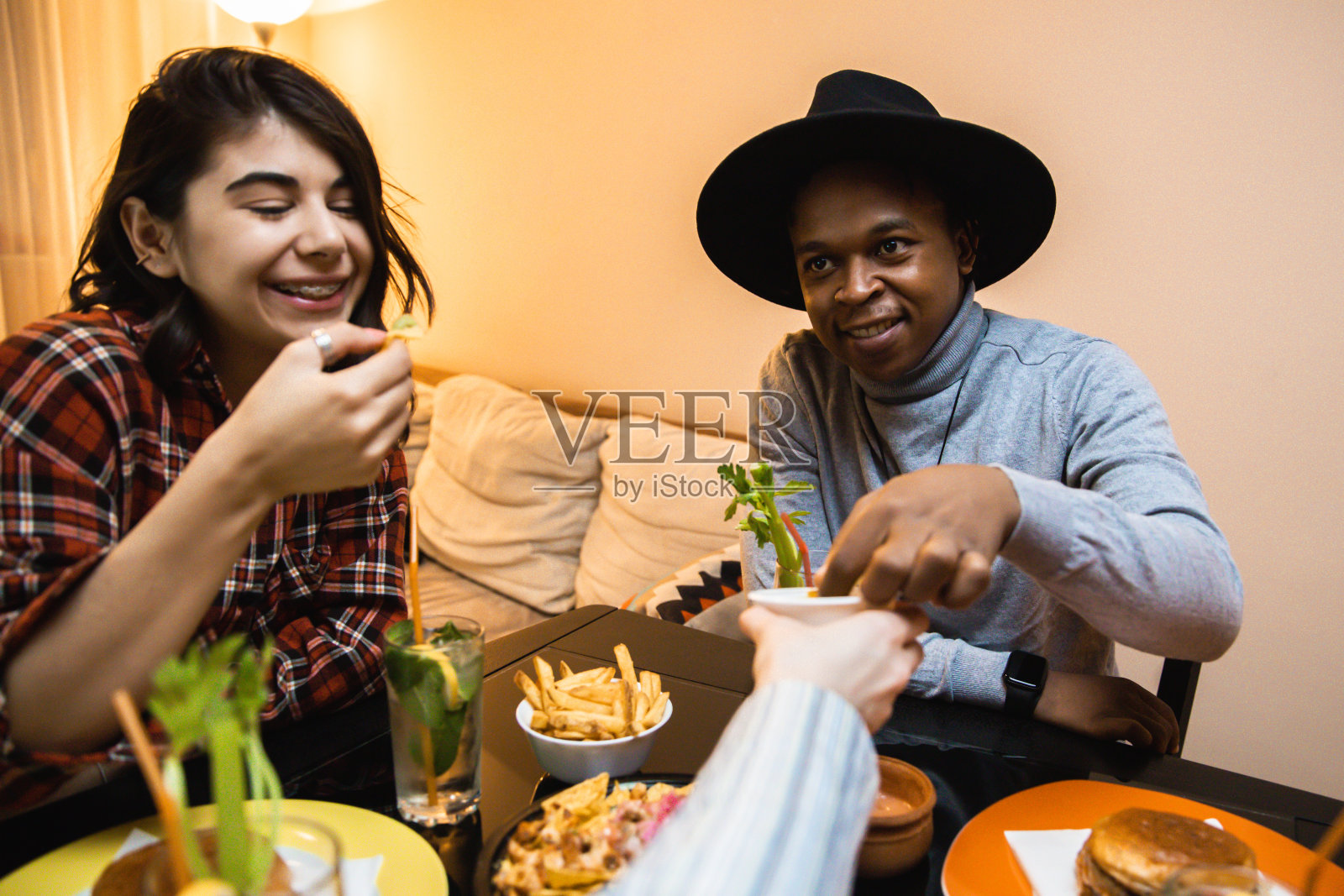 一群年轻人吃着玉米片，喝着鸡尾酒照片摄影图片