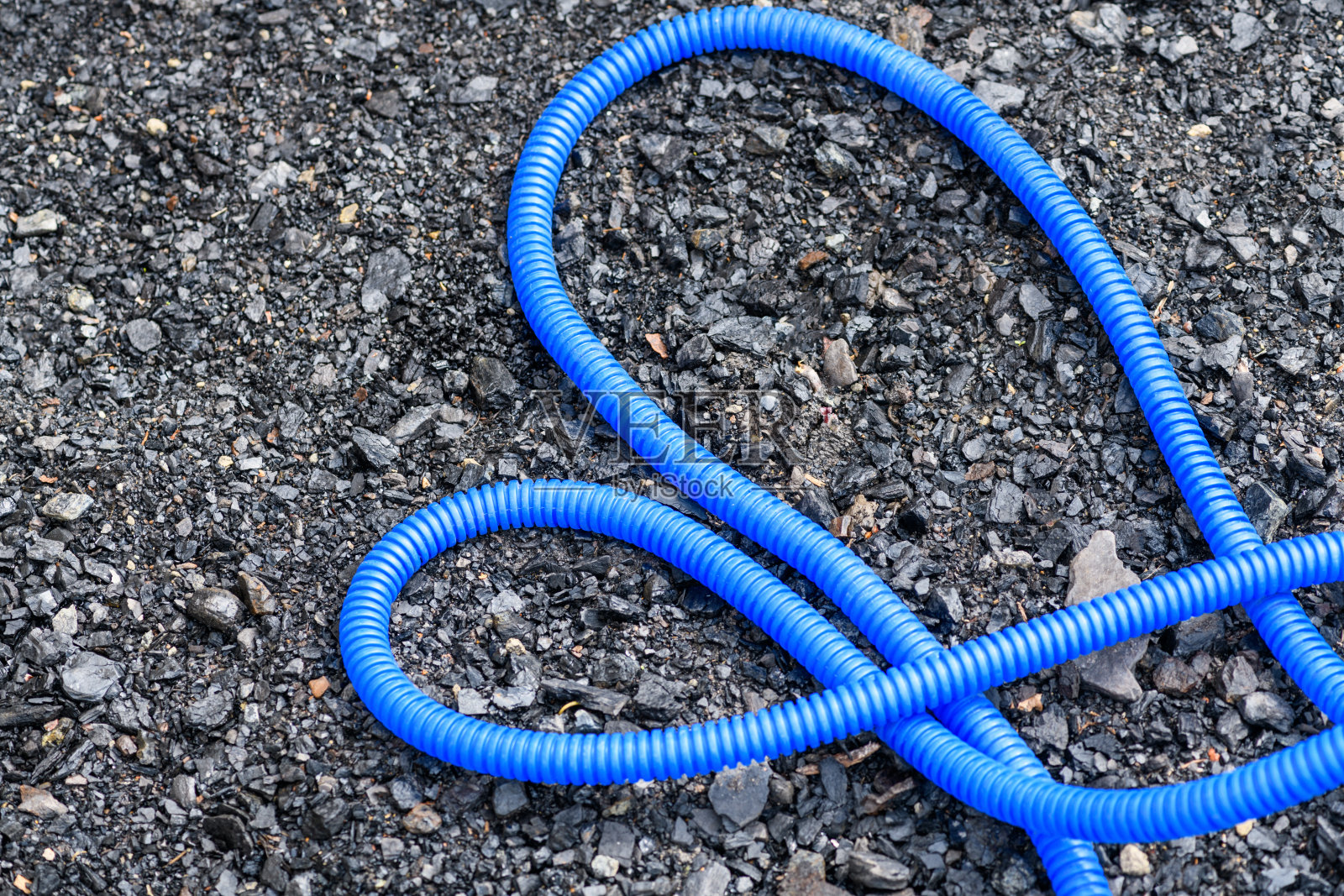 蓝色塑料软管用于灌溉地面照片摄影图片