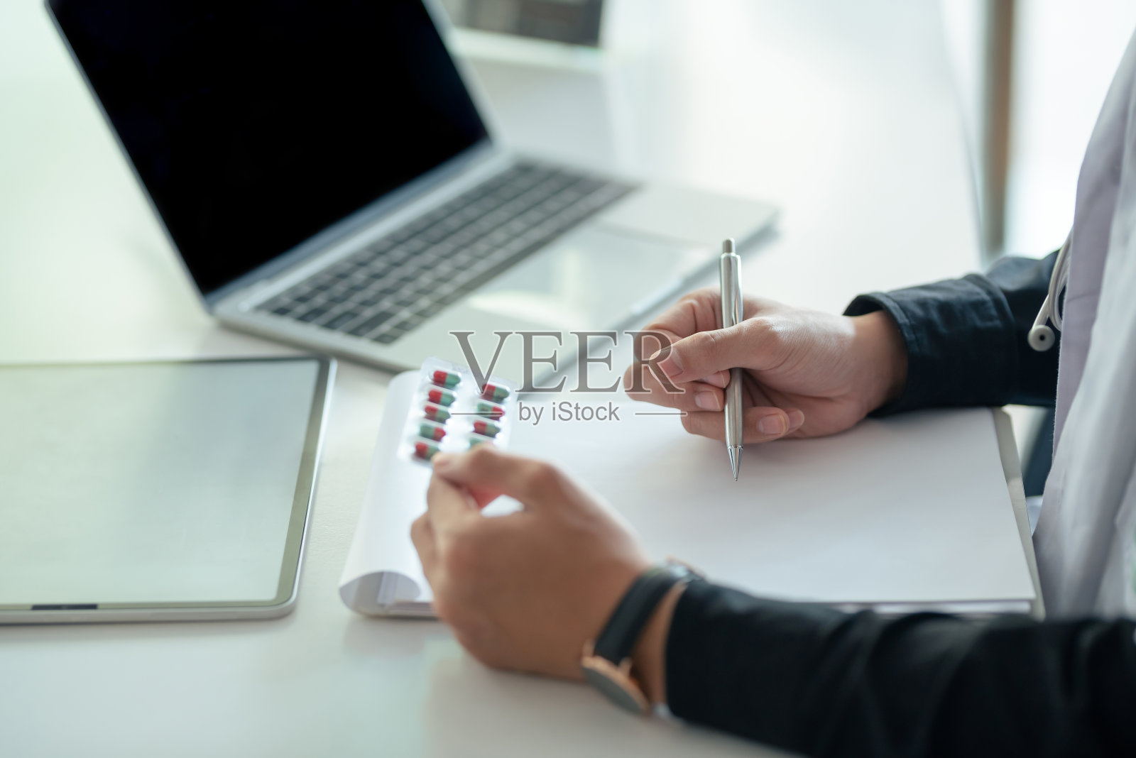 男医生正在为病人准备药。照片摄影图片