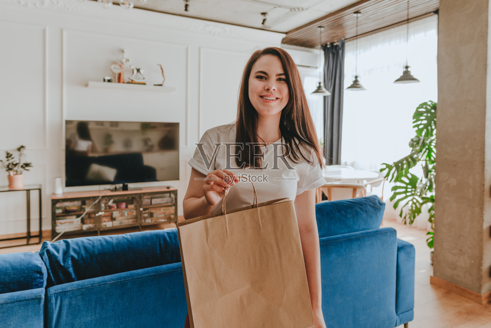 美丽的年轻女子手持空白的牛皮纸包照片摄影图片