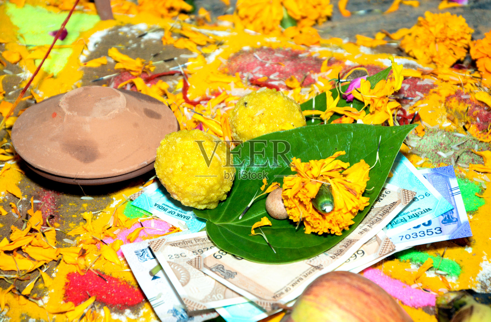 黄色的万寿菊花瓣和放在叶子下的钞票照片摄影图片