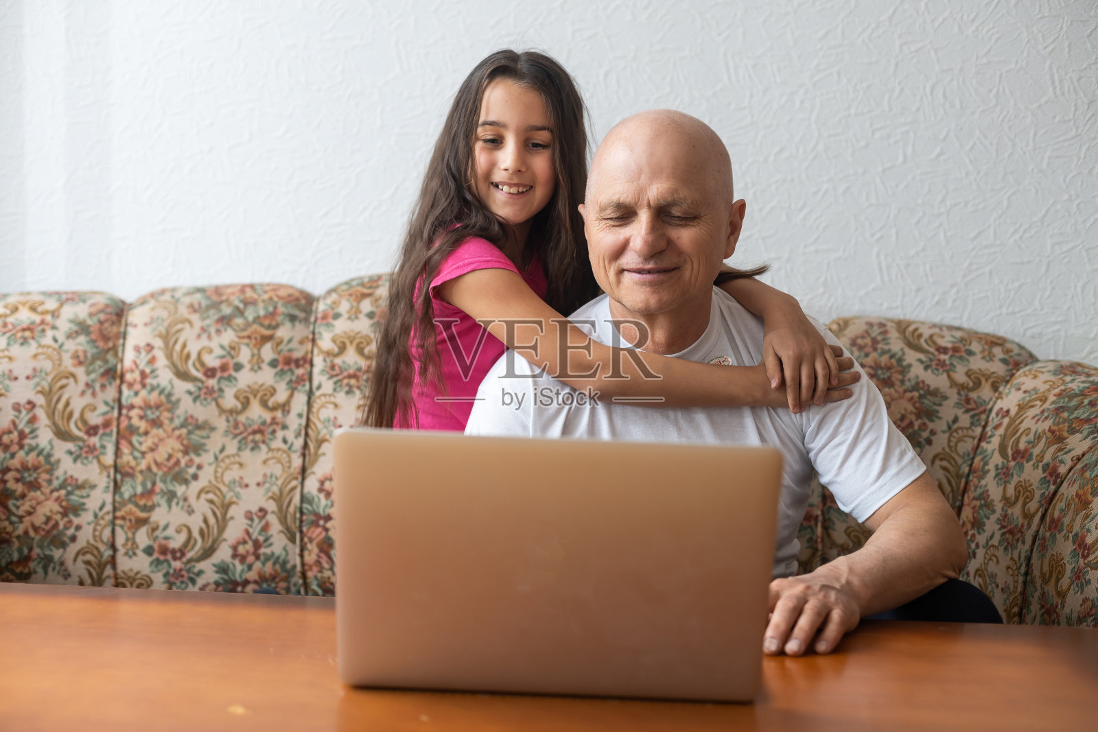 爷爷和孙女花时间在一起使用笔记本电脑，浏览网站，年轻一代教解释如何使用现代科技概念照片摄影图片