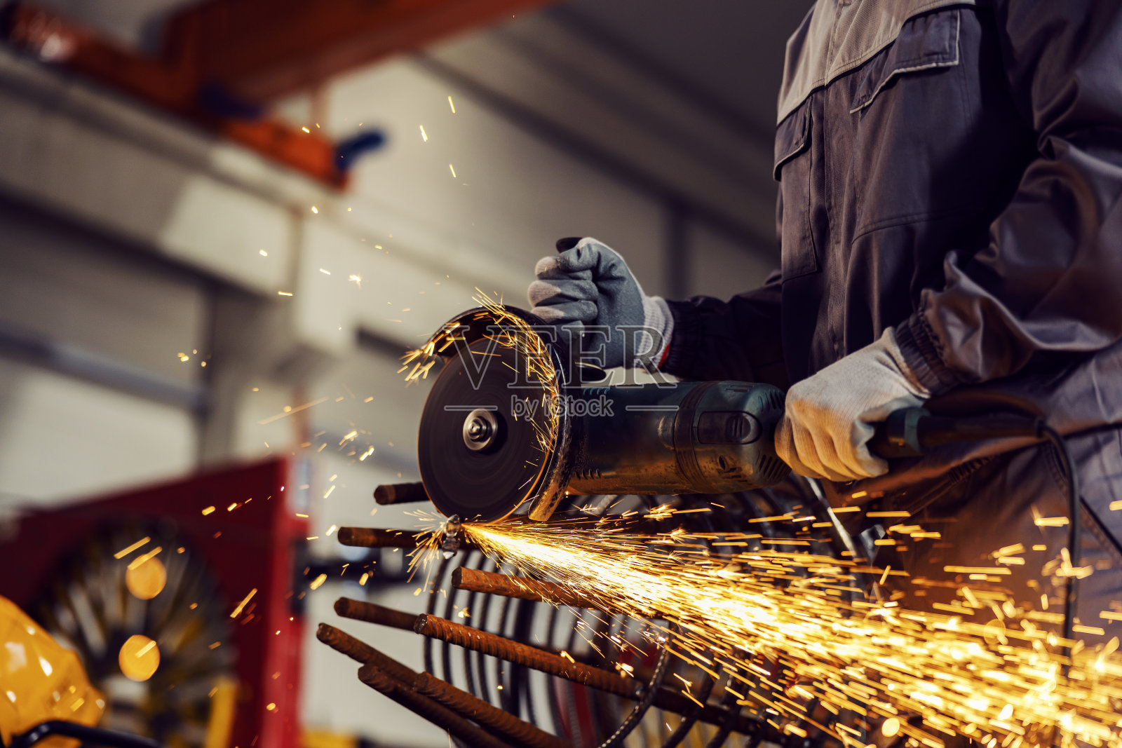 重工业工人在工厂用磨床磨金属框架的特写。照片摄影图片