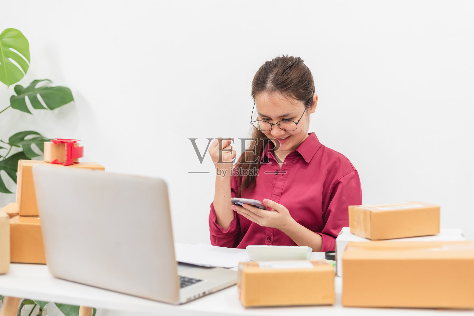 电子商务和在线销售概念，快乐的亚洲女性在从智能手机查看订单和支付余额时举起了拳头。照片摄影图片