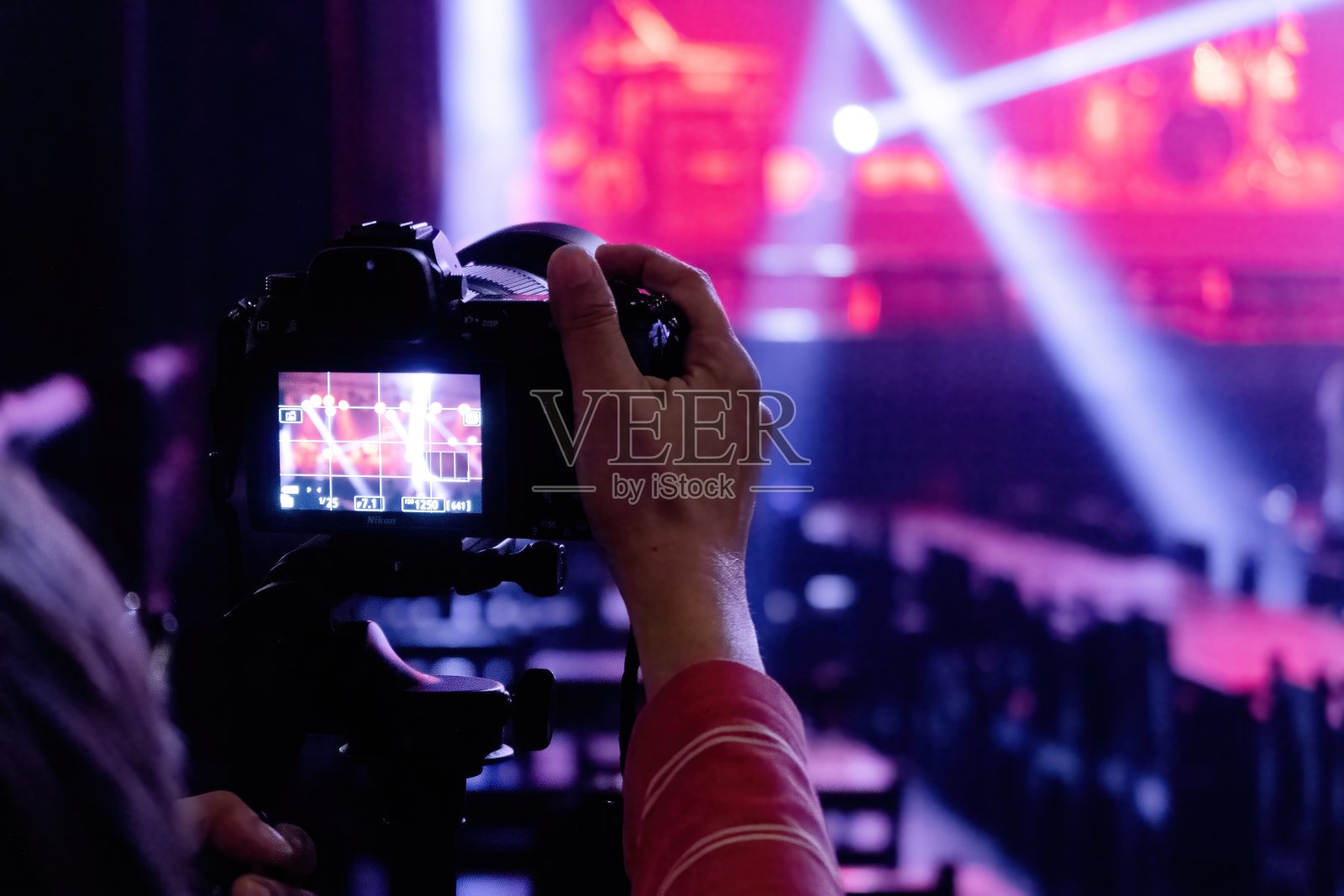 人们在弱光条件下使用相机的音乐会舞台。照片摄影图片