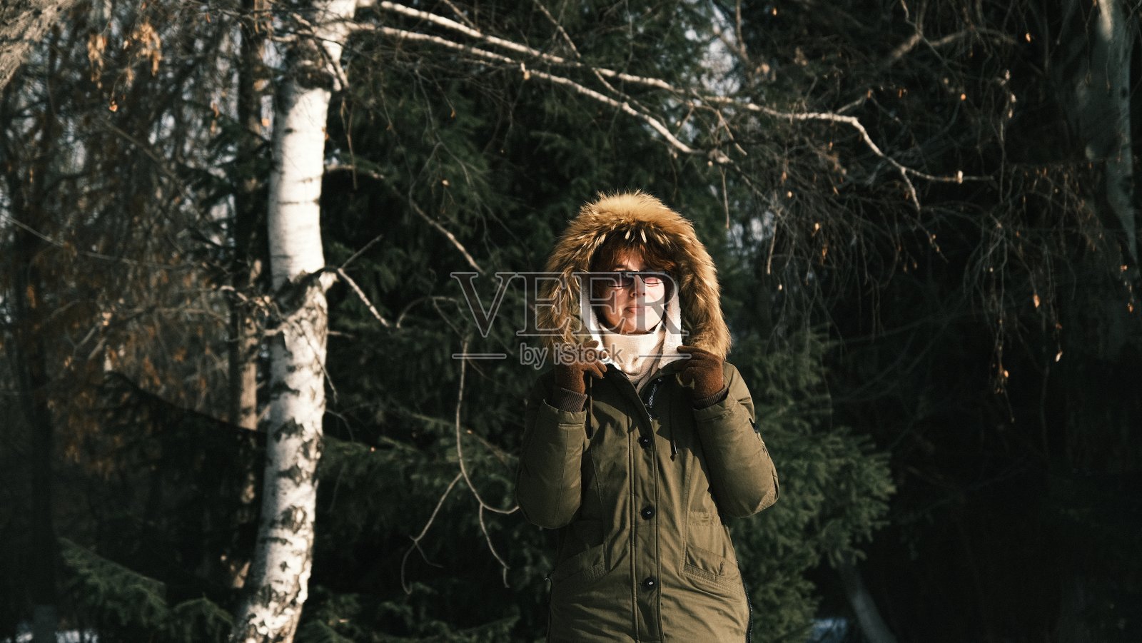 在阳光明媚的冬日公园里，成熟女人的肖像照片摄影图片