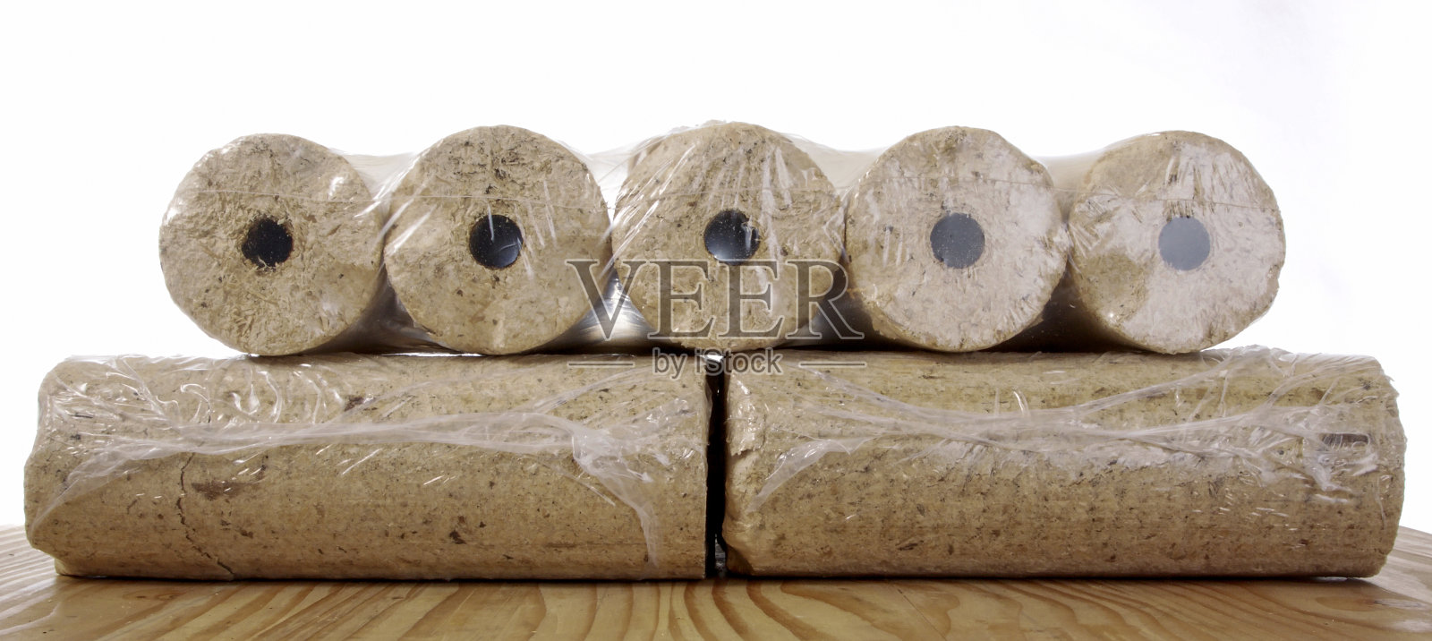 用塑料薄膜包裹的圆形木制煤球孤立在白色背景上照片摄影图片