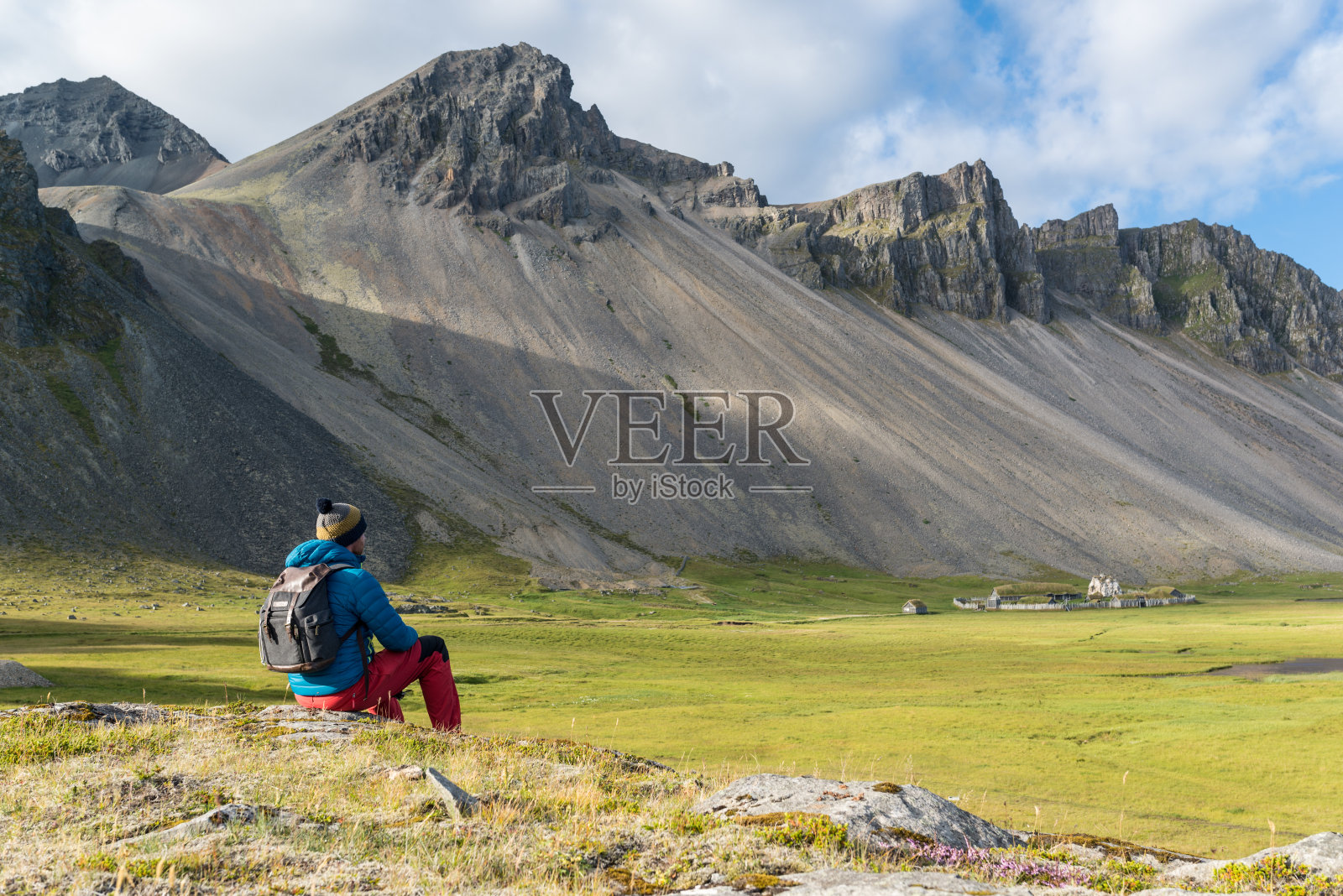 一名男子坐在冰岛斯托克斯涅斯半岛的维京村庄。照片摄影图片
