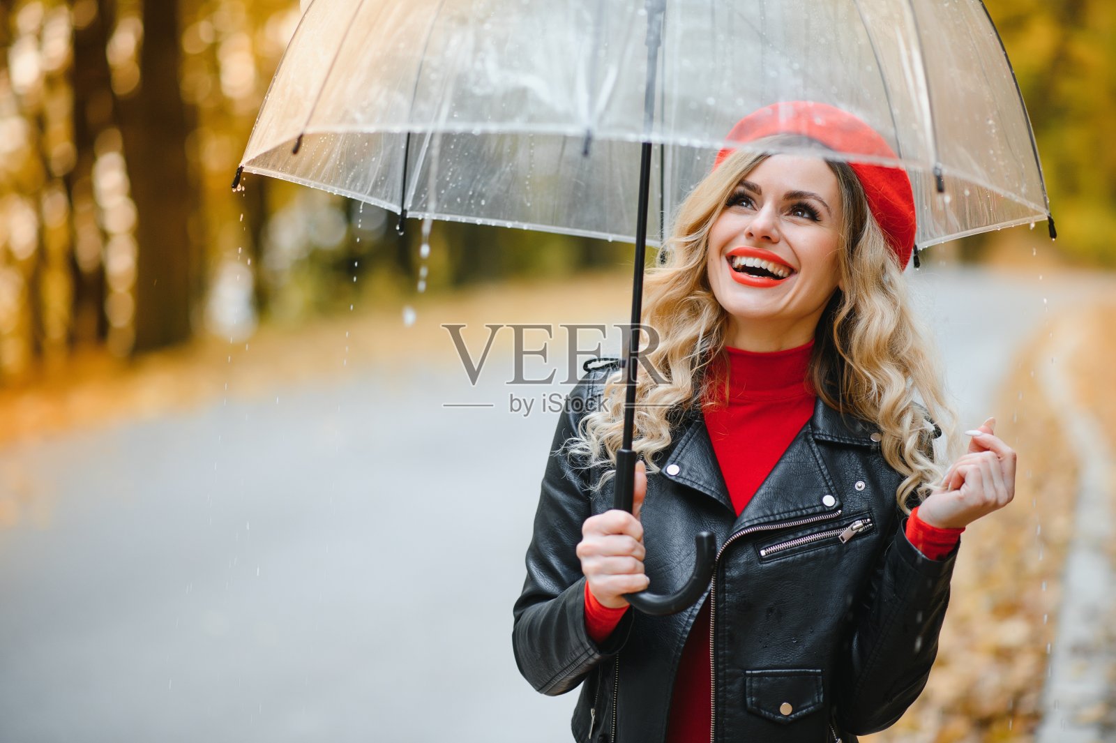 美丽的女孩在秋天公园打着伞。照片摄影图片