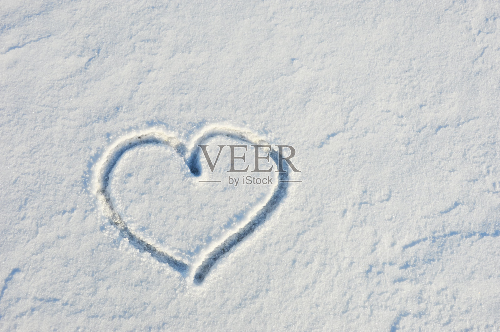 冬天白雪上的一颗心。爱，情人节。设计背景。二月十四日。照片摄影图片