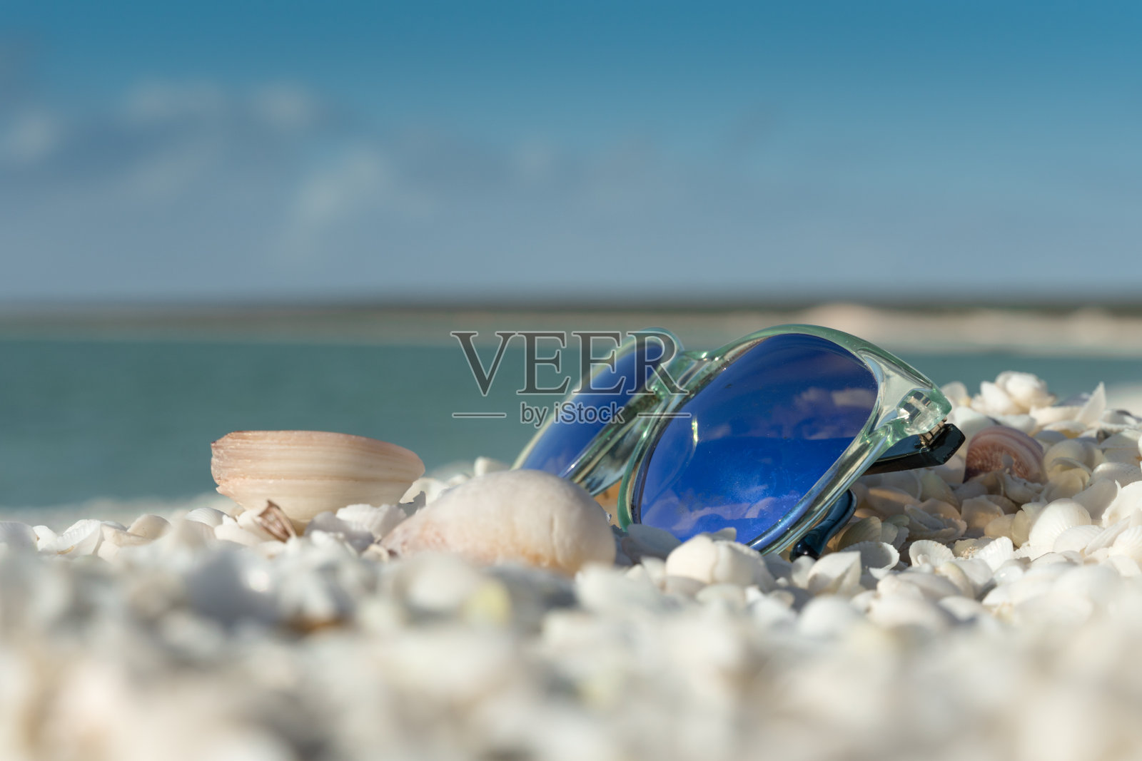 阳光明媚的海滩，带着太阳镜和贝壳照片摄影图片