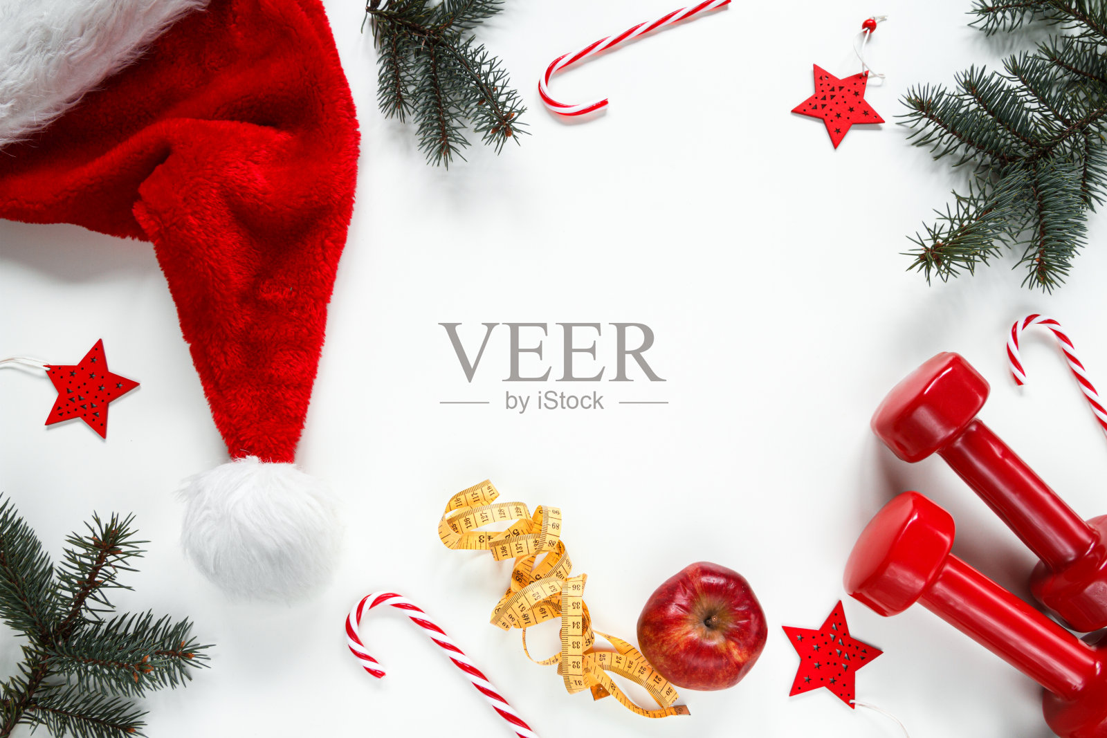 圣诞节健身房平铺构图与复制空间。哑铃，圣诞老人帽子和节日装饰品。照片摄影图片