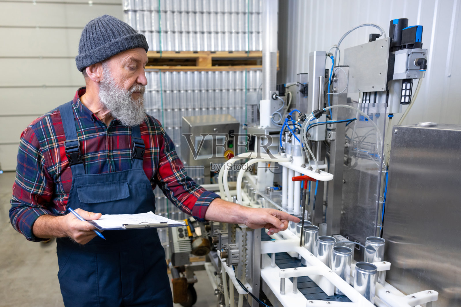 生产操作工控制液体灌装机的操作照片摄影图片