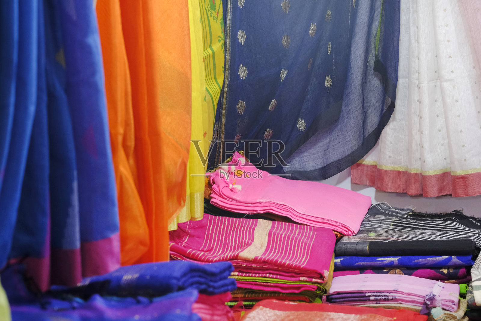 艺术品种的阴影色调色彩装饰图案，近距离观察堆叠的莎丽或在零售商店的展示。照片摄影图片