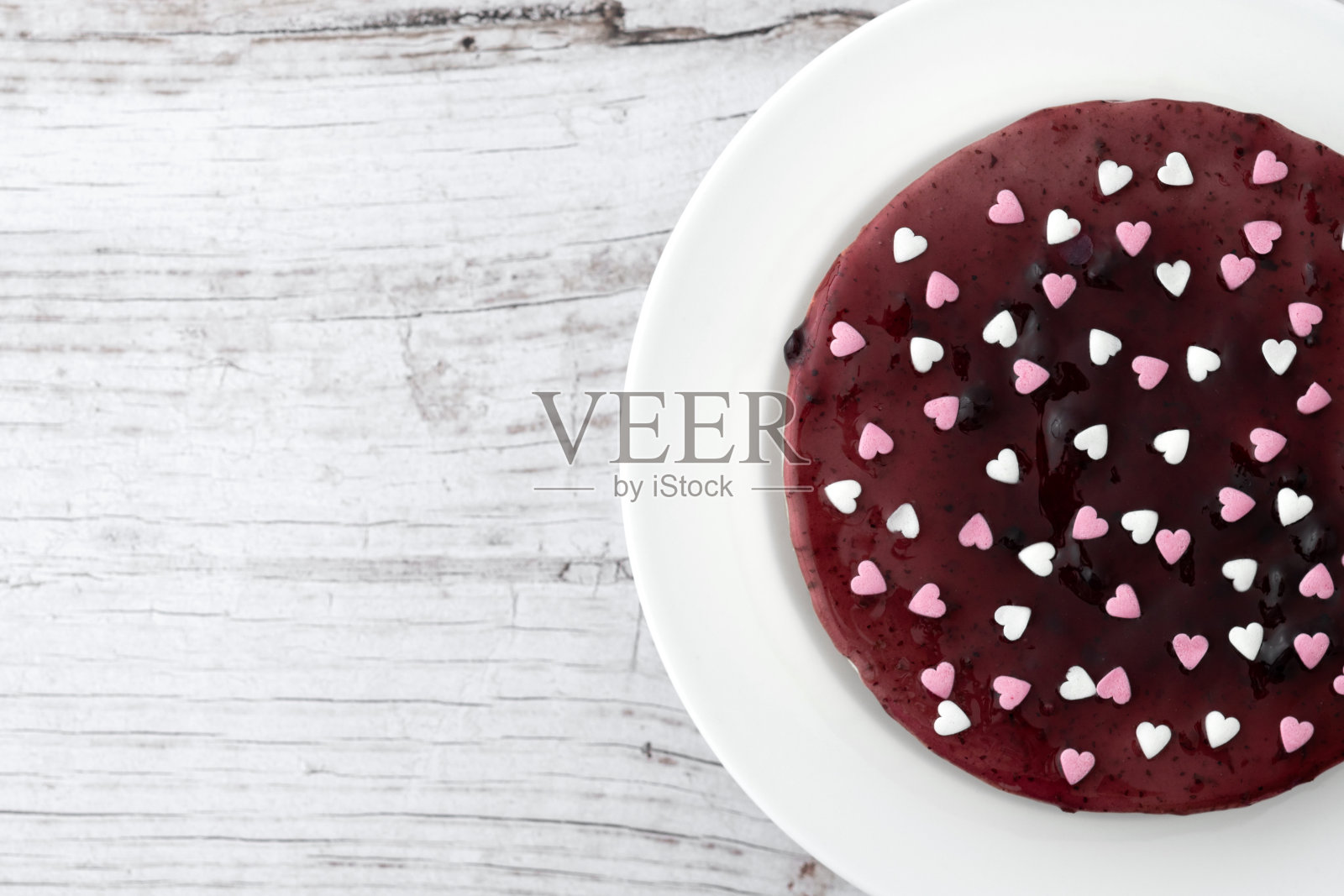 木桌上装饰着心形的蓝莓芝士蛋糕照片摄影图片