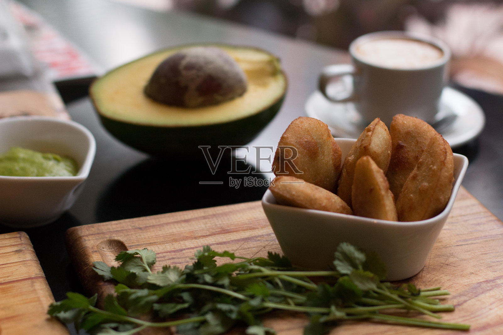 餐桌上有一碗牛油果和香菜的肉馅卷饼照片摄影图片