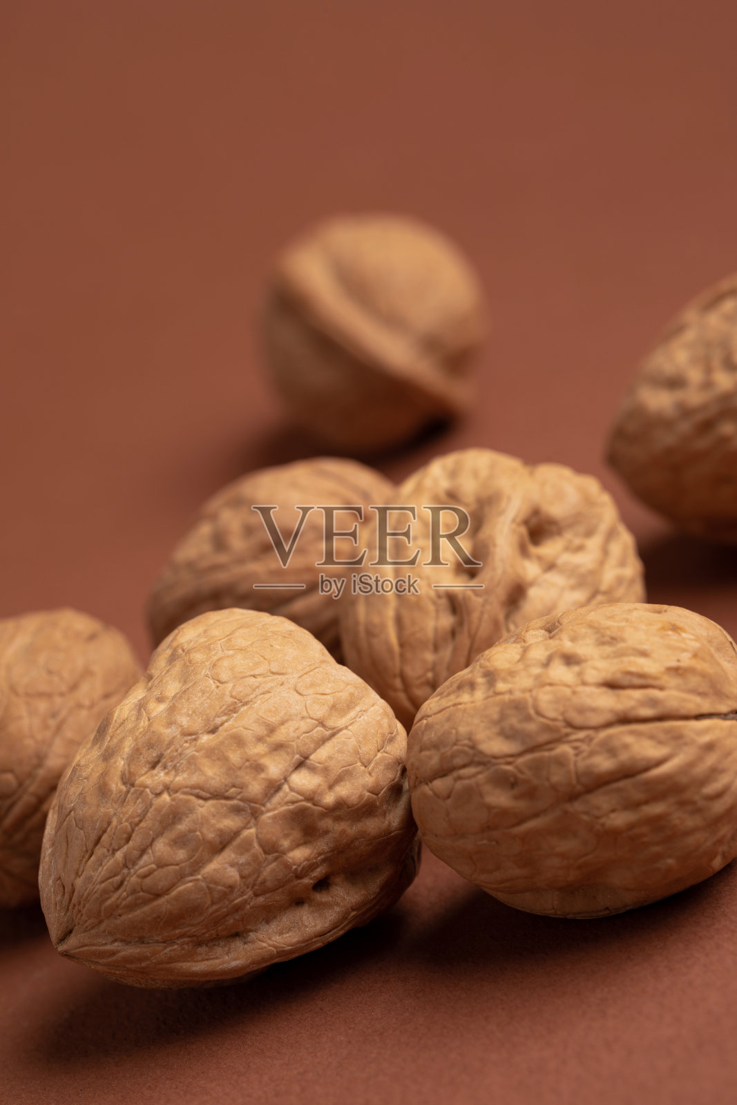 粉色背景上的坚果垂直镜头照片摄影图片