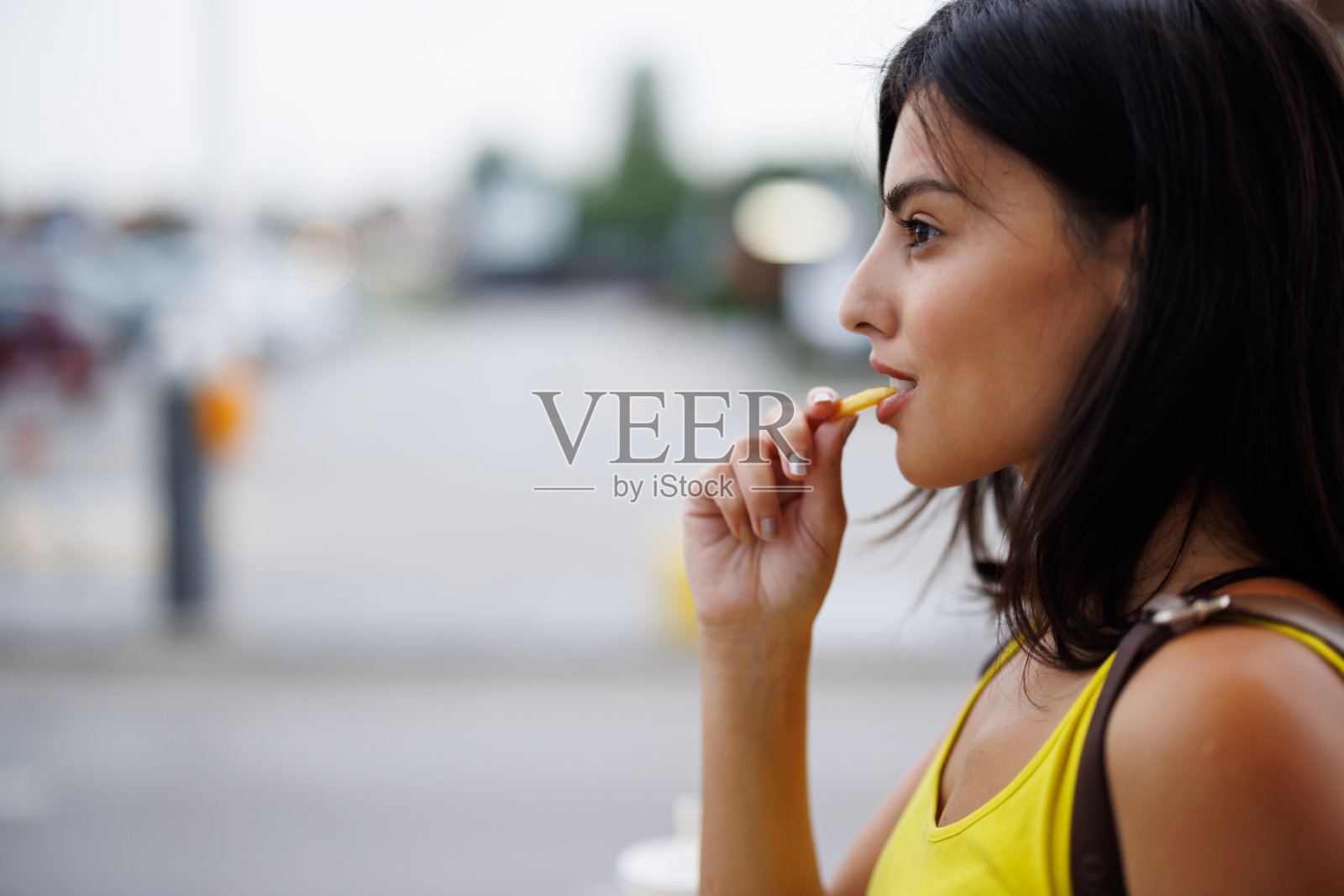 女人在城市里吃快餐照片摄影图片