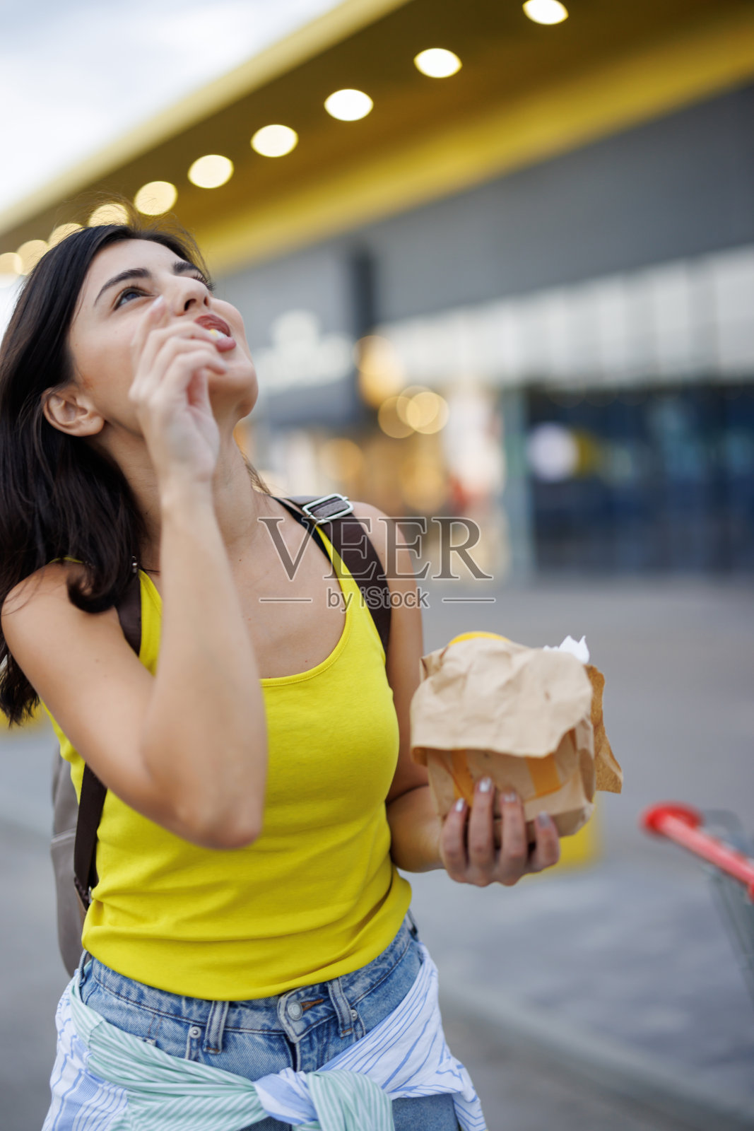 女人在城市里吃快餐照片摄影图片