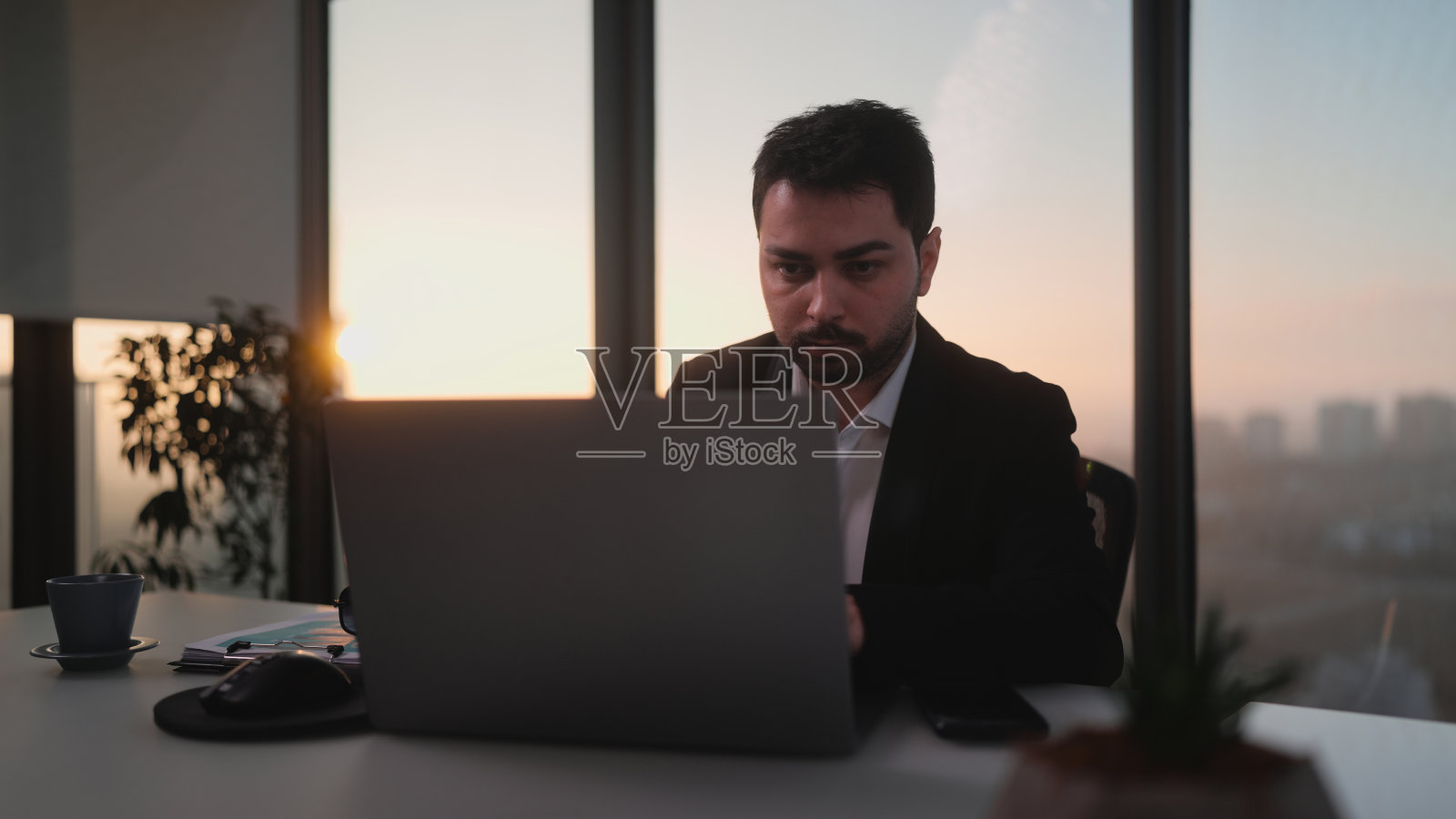 年轻的商人在办公室的笔记本电脑上工作照片摄影图片