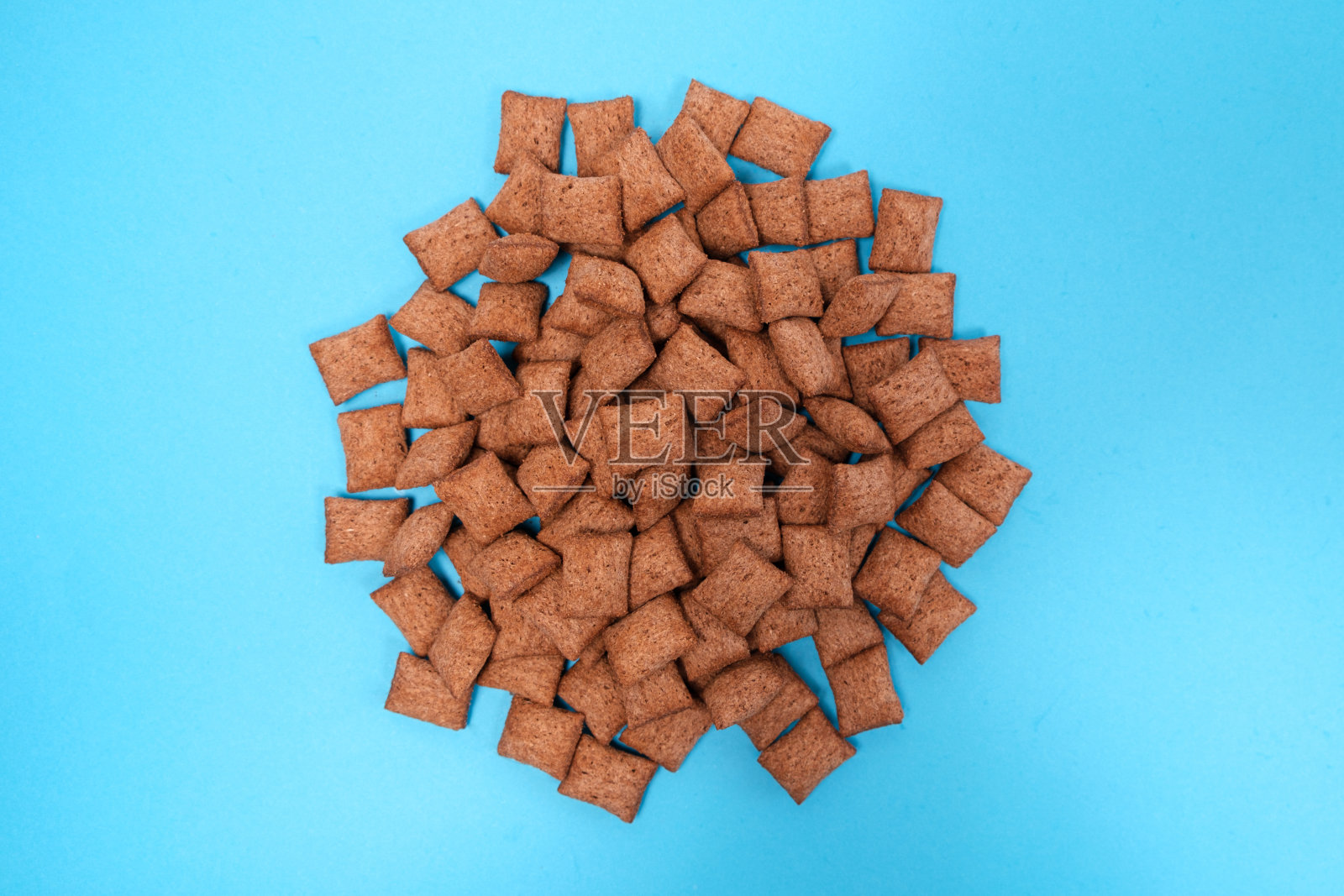 香甜的麦片早餐——蓝色背景的巧克力面包片，从上面看。照片摄影图片