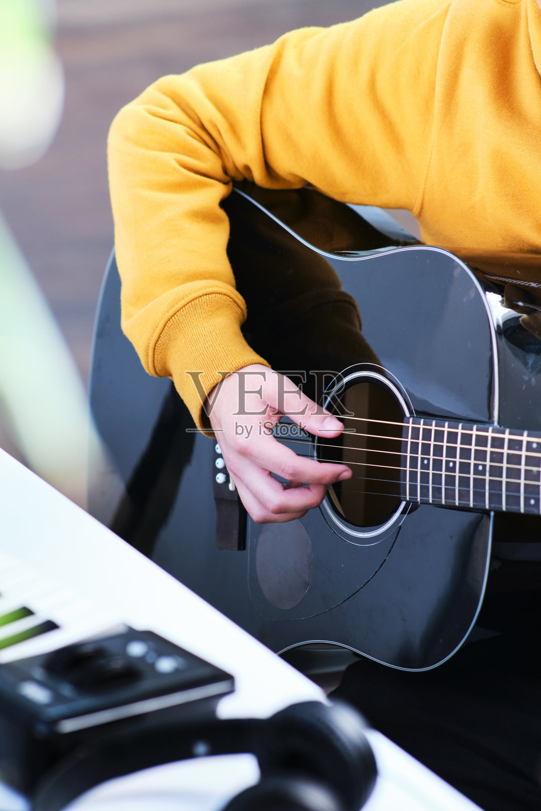 一个弹吉他的年轻人的腹部视图照片摄影图片