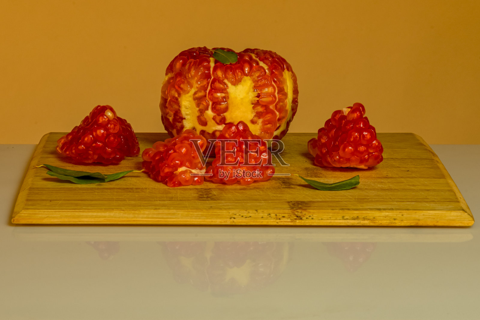 静物的石榴，在一个木桌和一个彩色背景。照片摄影图片