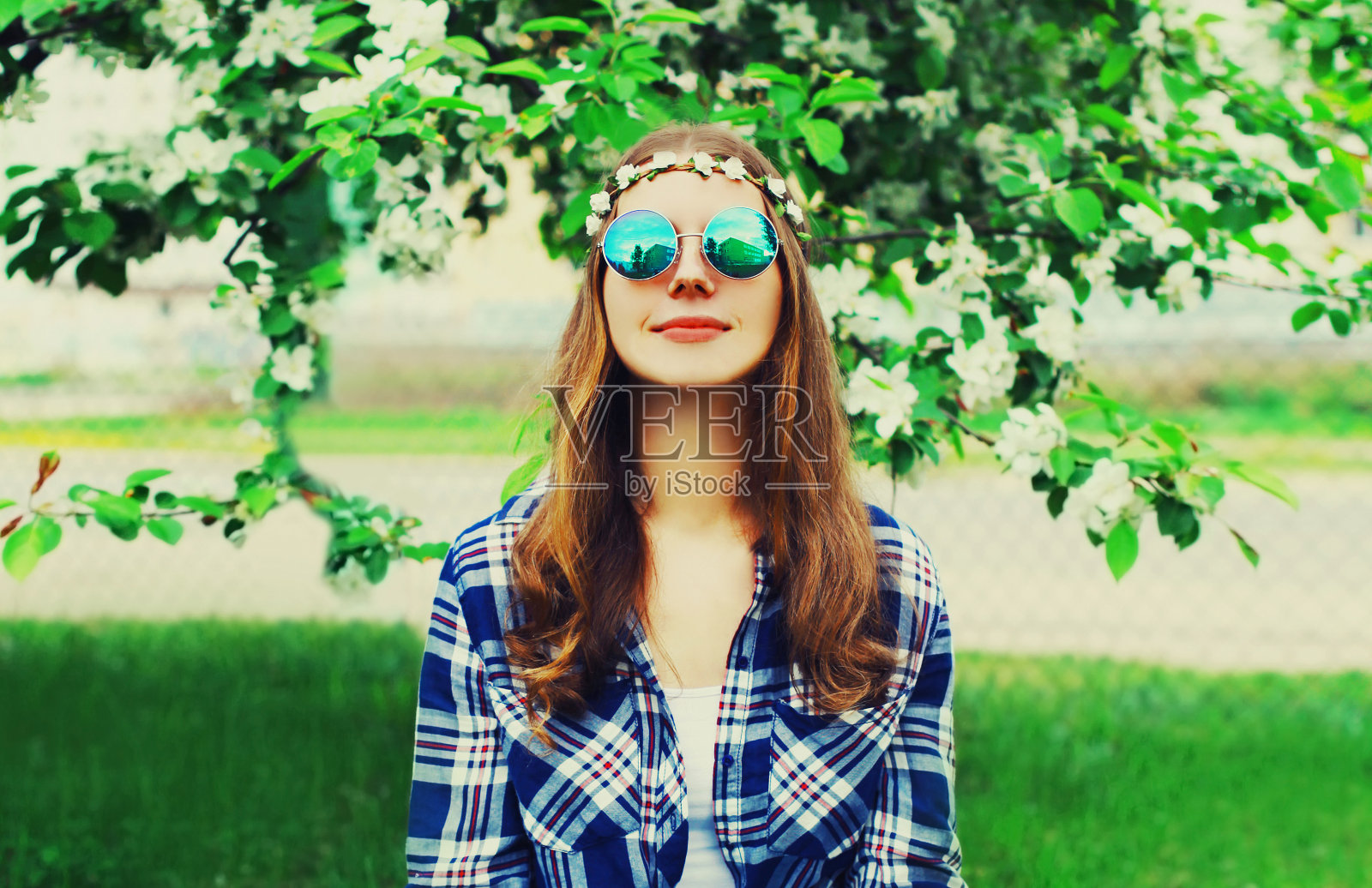 美丽的年轻女子肖像戴花头巾，太阳镜在花园或公园照片摄影图片