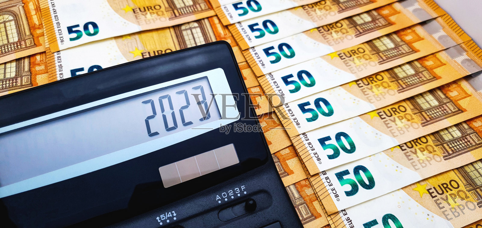 2023年新年。以50欧元纸币为背景，屏幕上显示数字2023的计算器照片摄影图片