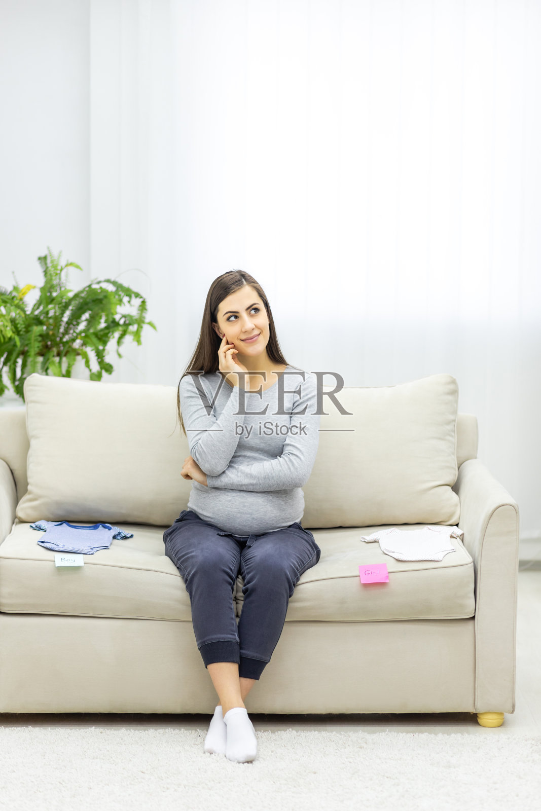 孕妇的照片，肚子上有粉红色和蓝色的纸，这意味着未来宝宝的性别。照片摄影图片