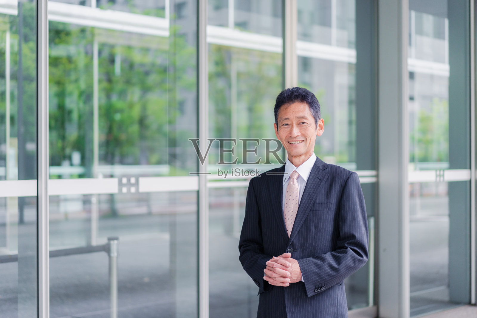 一个商人站在他的楼前照片摄影图片