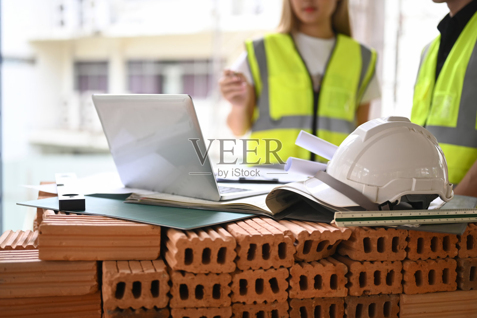 年轻的工程师和建筑师团队在施工现场工作，讨论，规划，测量建筑图纸的布局。照片摄影图片