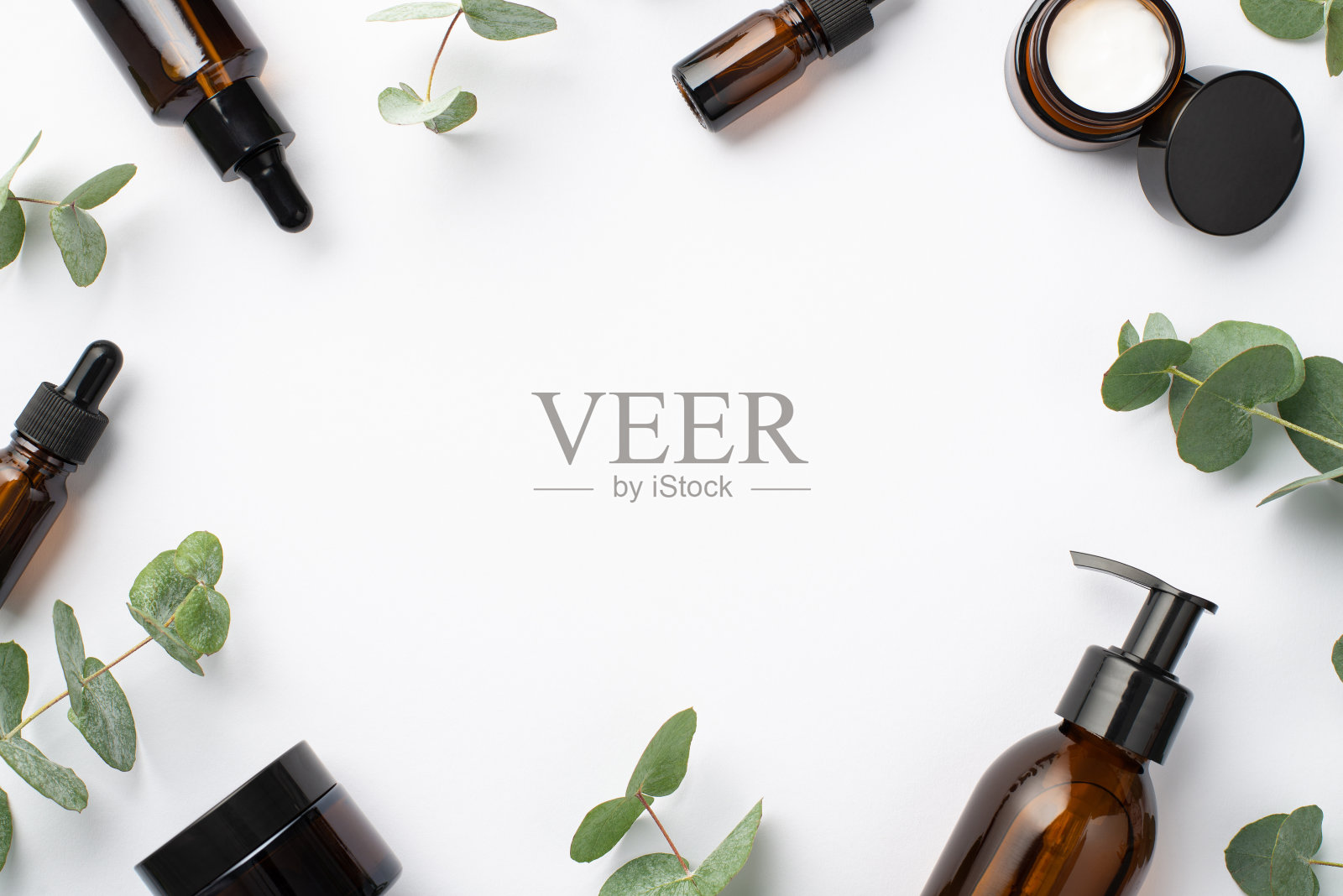 天然化妆品的概念。顶视图照片的玻璃瓶，奶油瓶和桉树叶子在孤立的白色背景与copyspace在te中间照片摄影图片