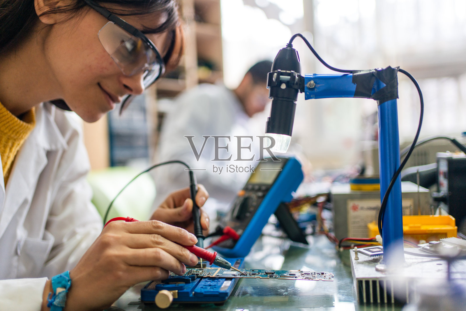 在办公室工作于电路板上的同事照片摄影图片