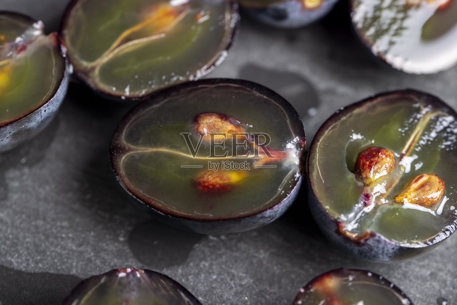 甜熟的黑葡萄切成两半照片摄影图片