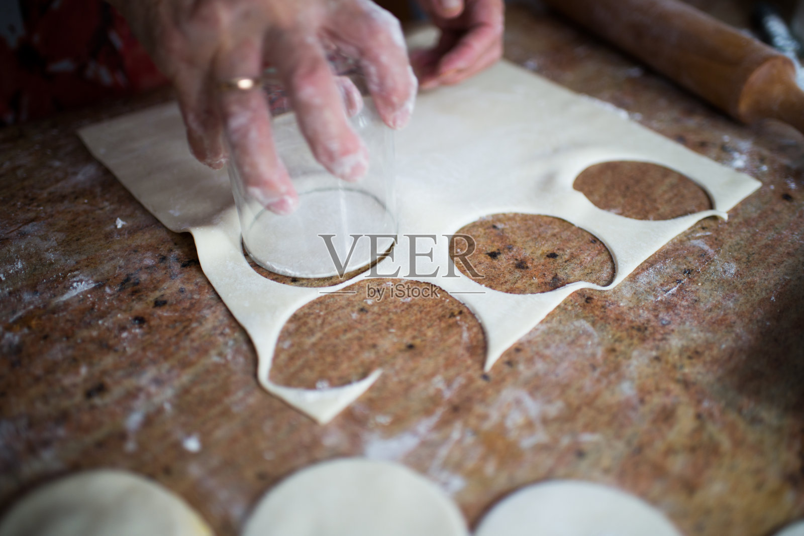 人手用玻璃杯切圆酥皮照片摄影图片