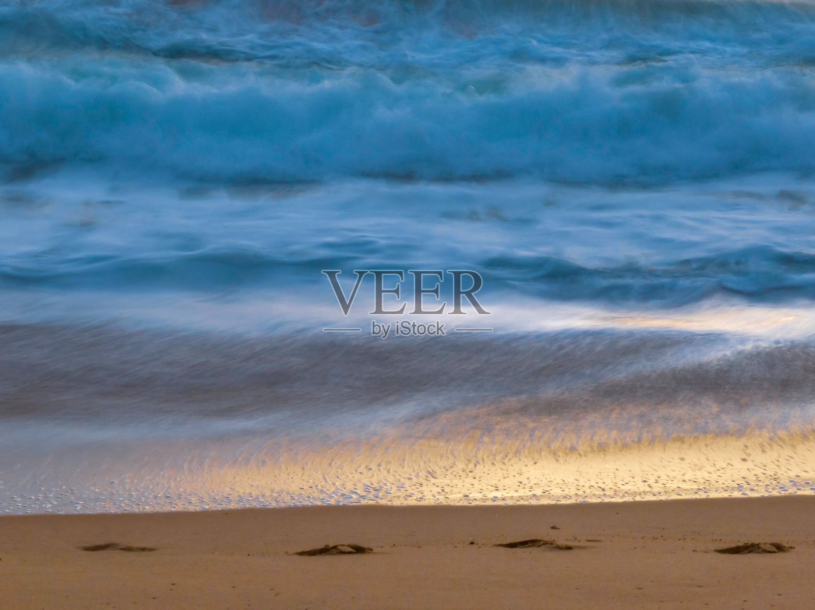 日出和沙滩上的脚印照片摄影图片