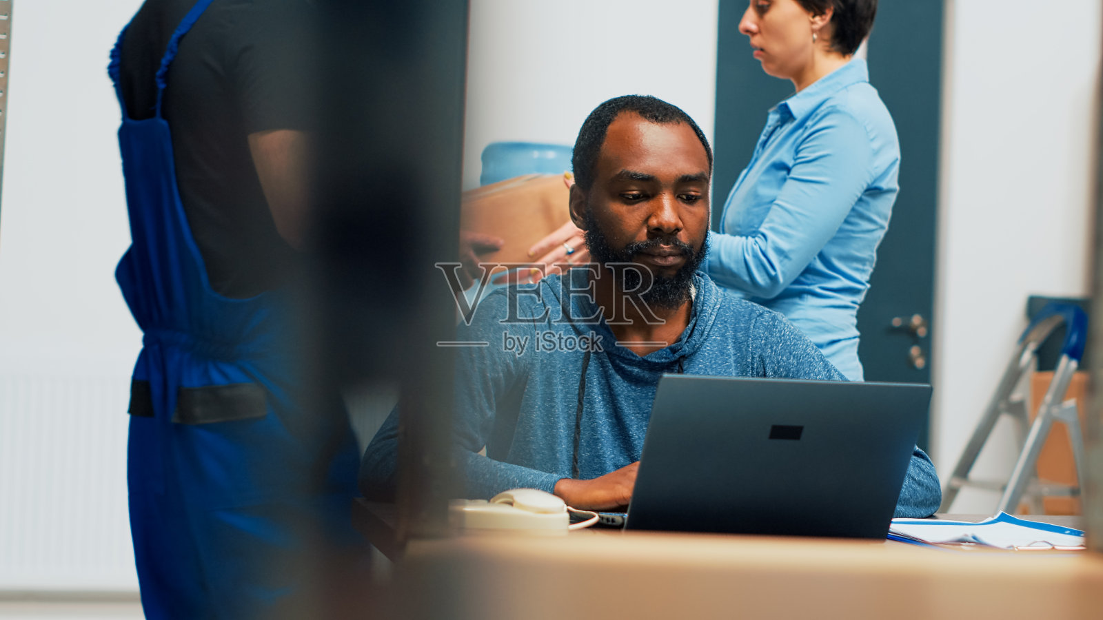 不同的办公室工作人员在发货前查看箱子里的产品照片摄影图片