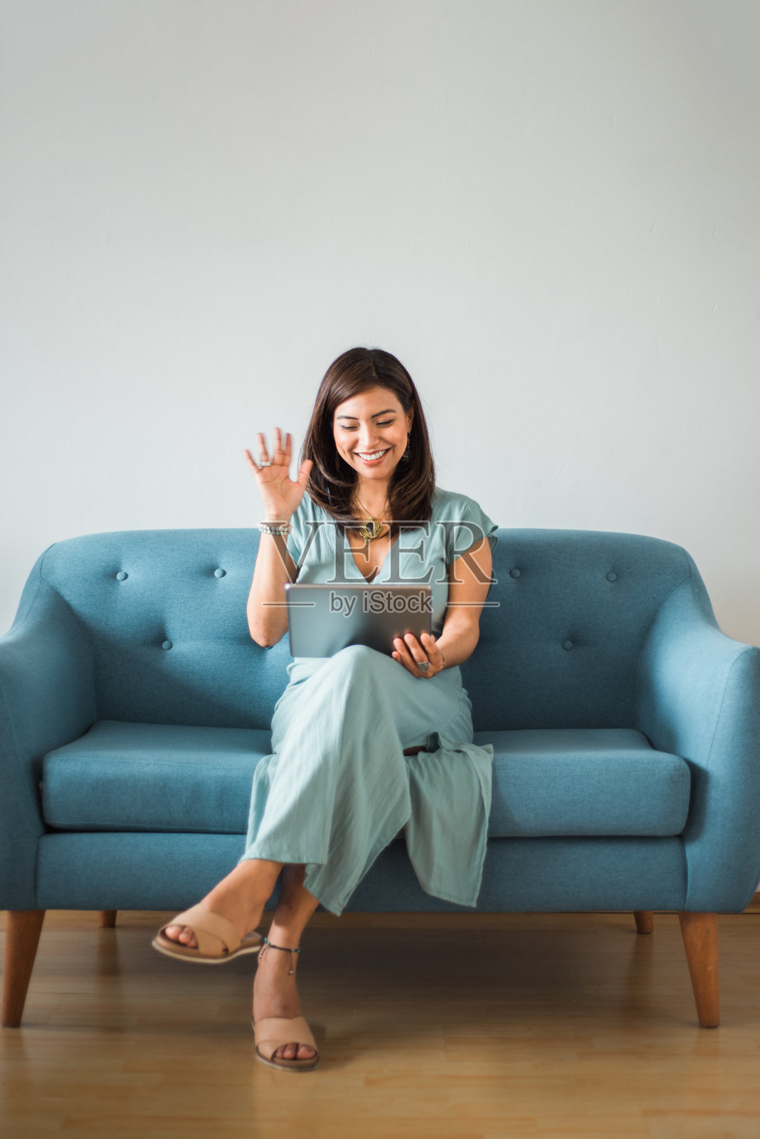 一名拉丁妇女在家里用视频电话打招呼照片摄影图片