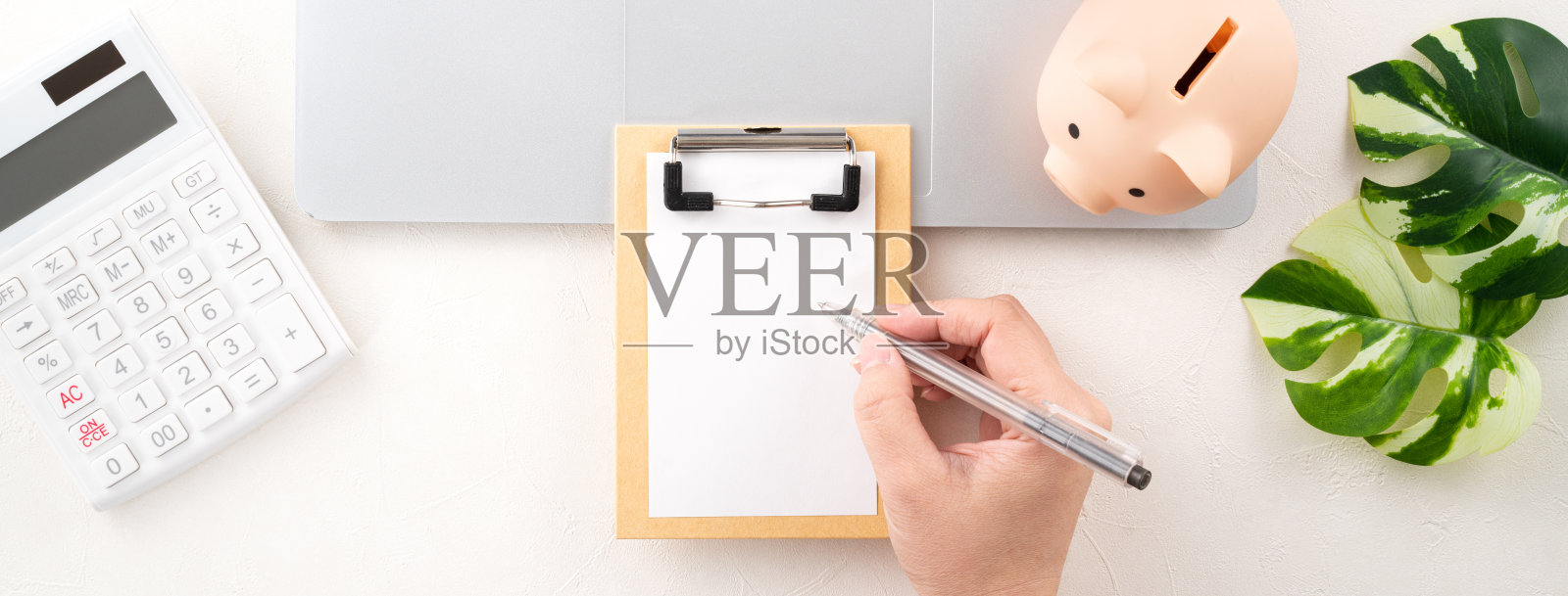 年度财务预算和储蓄计划的设计概念与笔记本电脑，存钱罐，计算器和笔记本电脑。照片摄影图片