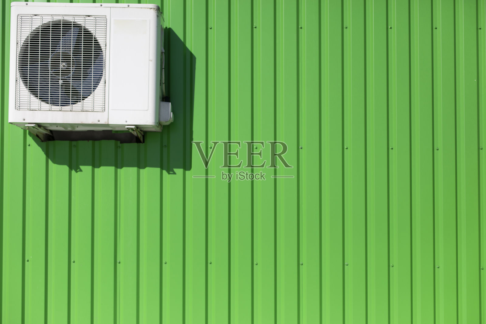 墙上有空调。冷却设备。工业建筑绿色墙面。照片摄影图片