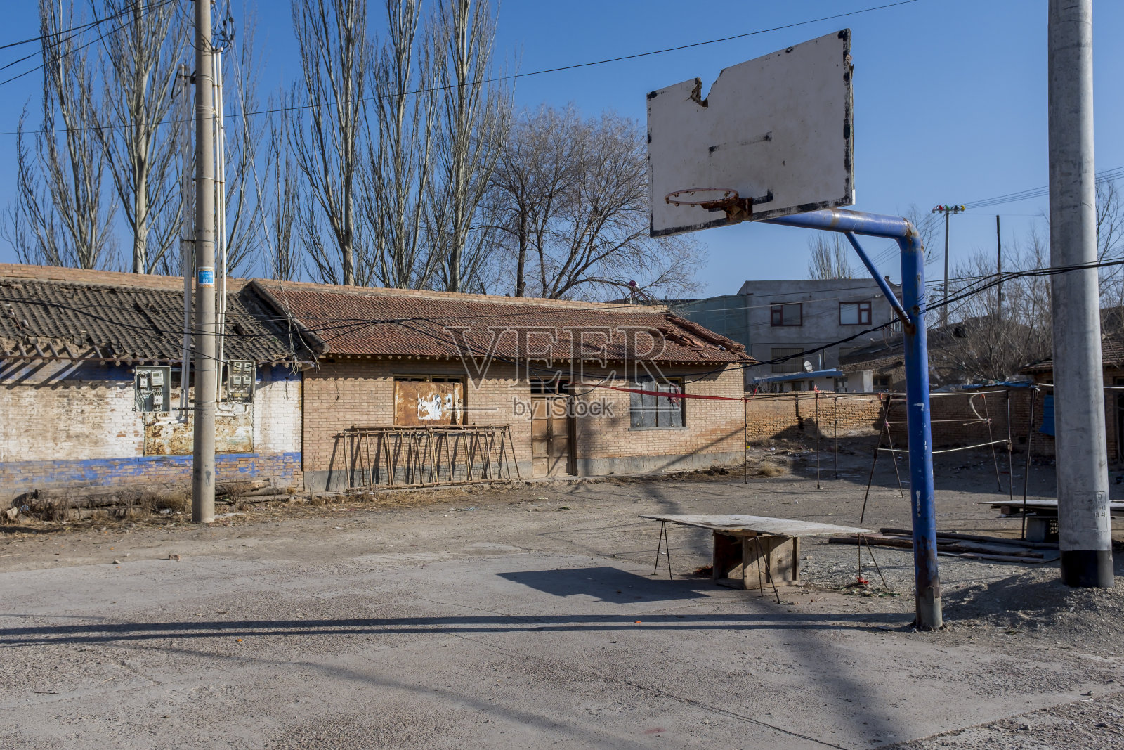 中国西部的一幢平房前，立着一个生锈的篮球照片摄影图片