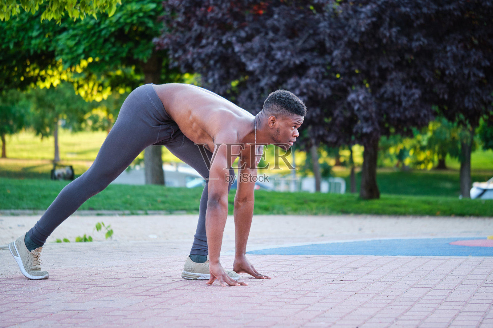 年轻健康的赤膊黑人男子准备在阳光明媚的夏日跑到户外。照片摄影图片